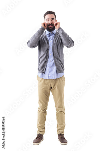 Smiling bearded hipster twirling mustache wearing smart casual clothes. Full body length portrait isolated on white studio background. 