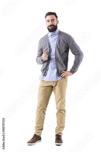Smiling stylish bearded modern business man pointing finger at you looking at camera. Full body length portrait isolated on white studio background. 
