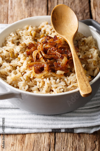 Arabic cuisine: rice with lentils and fried onions close-up in a bowl. vertical
