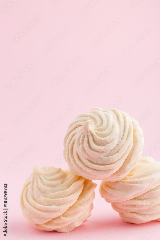 Homemade white zephyr or marshmallow on pink background Homemade white zephyr or marshmallow on pink background