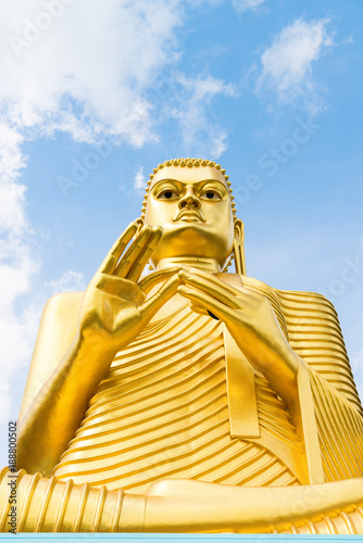 Big golden Buddha statue in wheel-turning pose