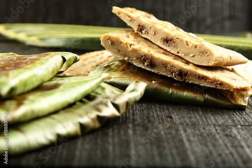 Ela ada - a Rice cakes filled with dry fruits wrapped in banana leaf cooked in fire  photo