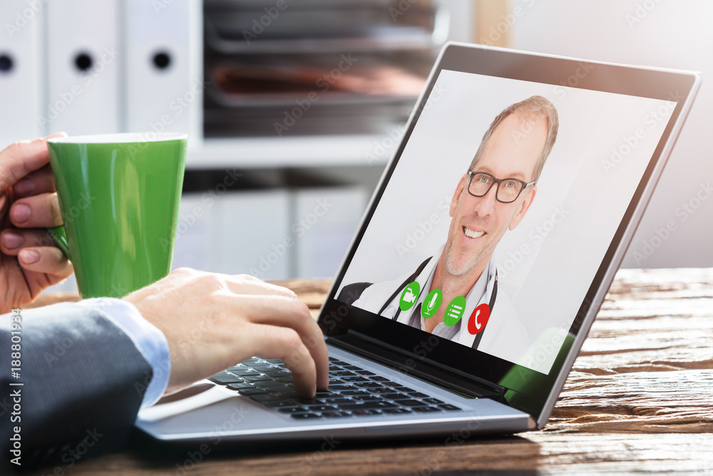 Person Video Conferencing With Doctor On Laptop Person Video Conferencing With Doctor On Laptop