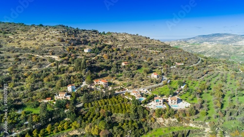 Aerial bird eye view of Miliou village hills and Akamas sea at Latchi, Paphos Cyprus. View of traditional ceramic tile roof houses near Ayii Anargyri monastery nature hotel spa from above.