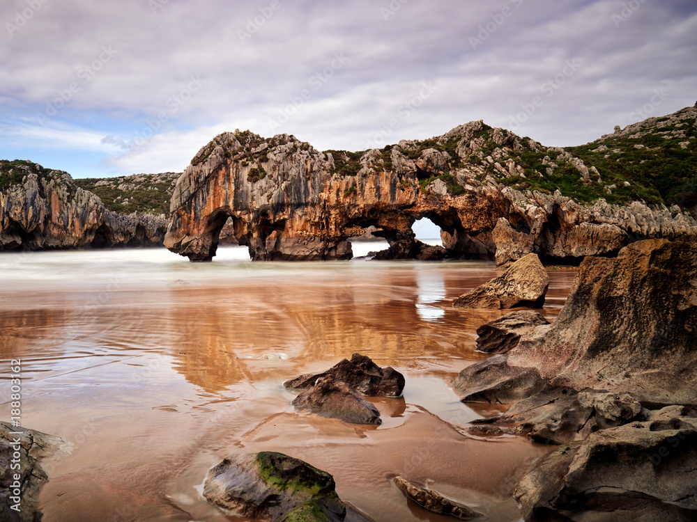 Beautiful stone arches on Playa de las Cuevas del Mar, Cantabria, Spain