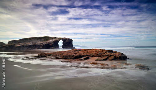 Beautiful sunset and stone arches on Playa de las Catedrales during inflow Spain