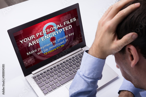 Businessman Looking At Laptop With Ramsomware Word On The Screen