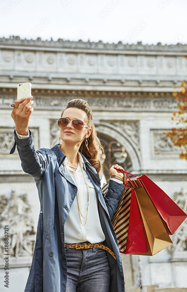 young woman shopper in Paris, France taking selfie with phone