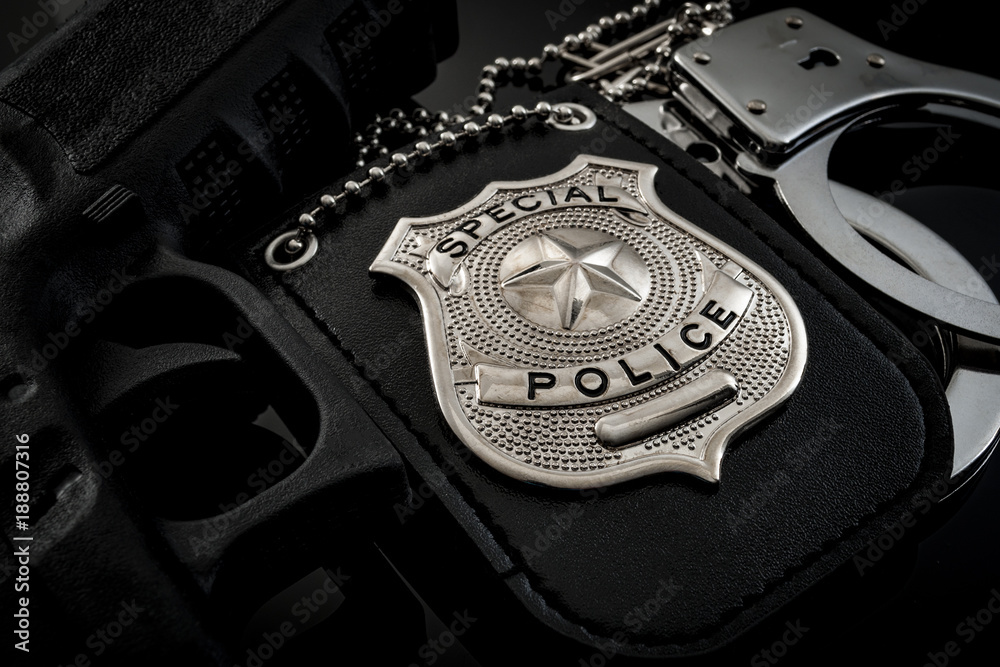 Protect and serve, crime fighting and blue lives matter concept with a police badge, a gun and a pair of handcuffs at night