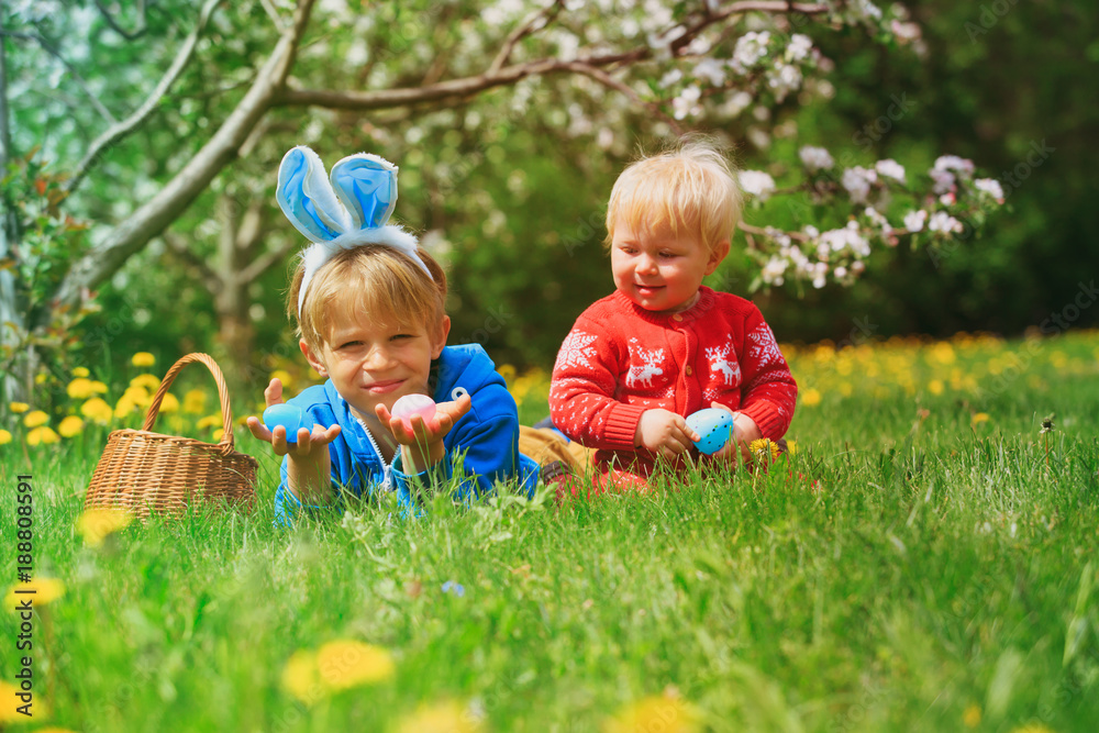 happy kids on easter eggs hunt in spring happy kids on easter eggs hunt in spring