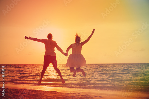 Happy loving couple enjoy tropical beach vacation at sunset