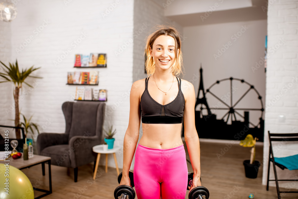 Portrait of a young woman doing sports with dumbbells at home Portrait of a young woman doing sports with dumbbells at home