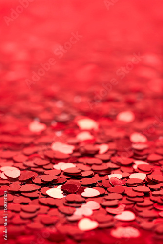 Image of red heart shape glitter with blur taken at a 45 degree angle.