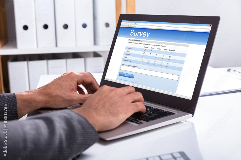 Businessperson Filling Online Survey Form On Laptop Businessperson Filling Online Survey Form On Laptop