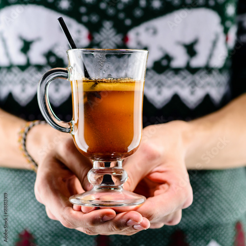 Man holding hot Buttered Becherovka cocktail with honey, cinnamon and anise photo