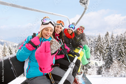 Girls with guy in ski lift taking photo