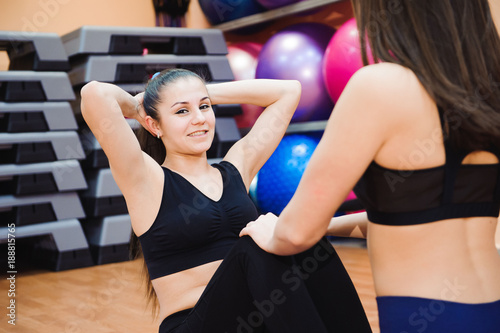 Two sporty women doing exercise abdominal crunches, pumping a press on floor in gym concept training exercising workout fitness aerobic