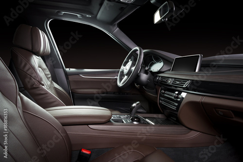 Modern luxury car Interior - steering wheel, shift lever and dashboard. Car interior luxury. Beige comfortable seats, steering wheel, dashboard, speedometer, display. Brown perforated leather. © gargantiopa