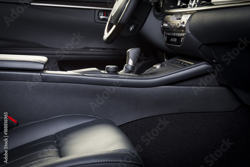 Dark luxury car Interior - steering wheel, shift lever and dashboard. Car interior luxury. Beige comfortable seats, steering wheel, dashboard, climate control, display. © gargantiopa