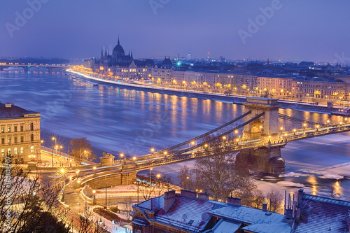 Winter twilight view of Budapest with Pest riverfront, Parliament domes outline and Chain bridge