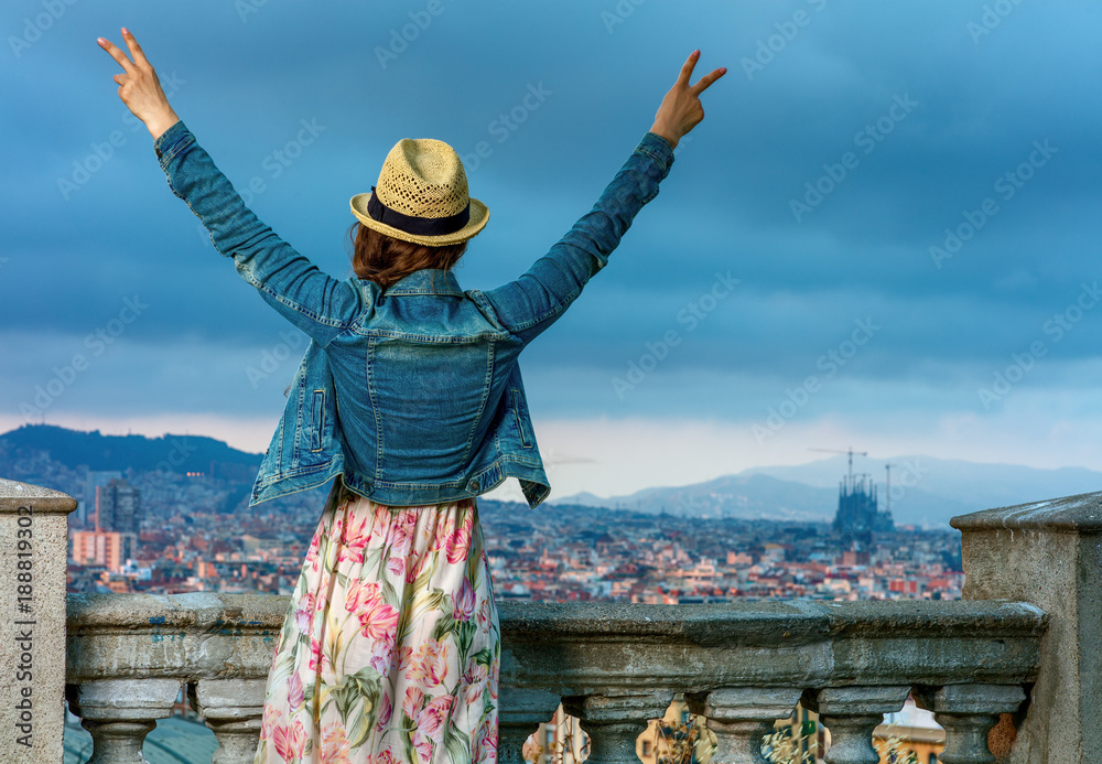Fototapeta premium traveller woman in front of cityscape of Barcelona rejoicing