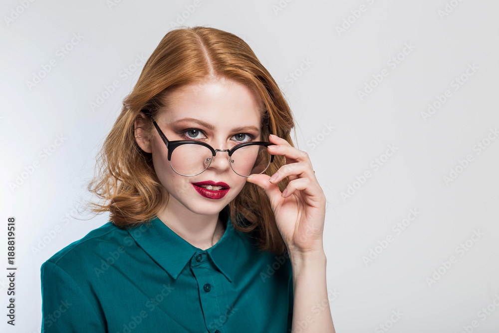 Mistrust and puzzled redhead woman in glasses, looking at camera. Studio shot Mistrust and puzzled redhead woman in glasses, looking at camera. Studio shot