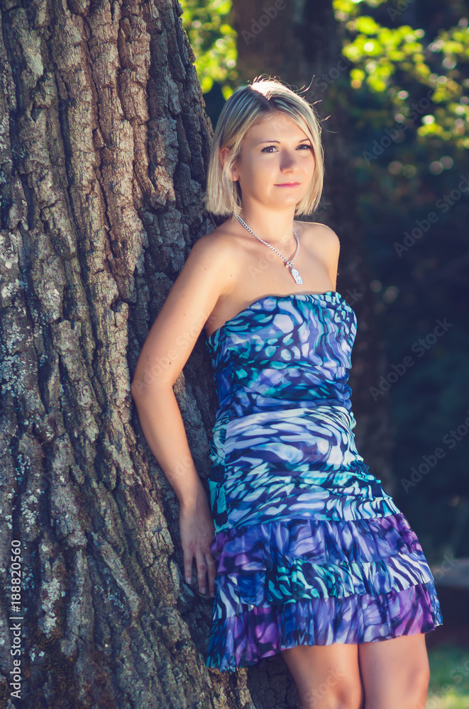 Portrait of fashionable young sensual blonde woman in garden lean on the tree. Portrait of fashionable young sensual blonde woman in garden lean on the tree.