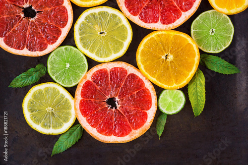 corner with slice of oranges, lemons, limes, grapefruit and mint pattern on black. Flat lay