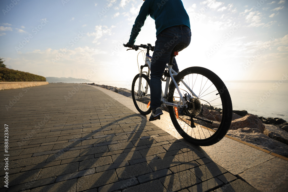 Fototapeta premium cyclist riding bike in the sunrise coast path