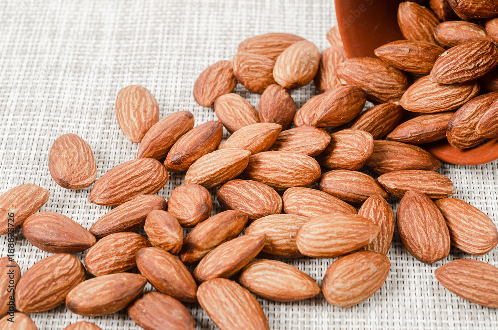 Fototapeta premium Almonds in bowl on sackcloth.