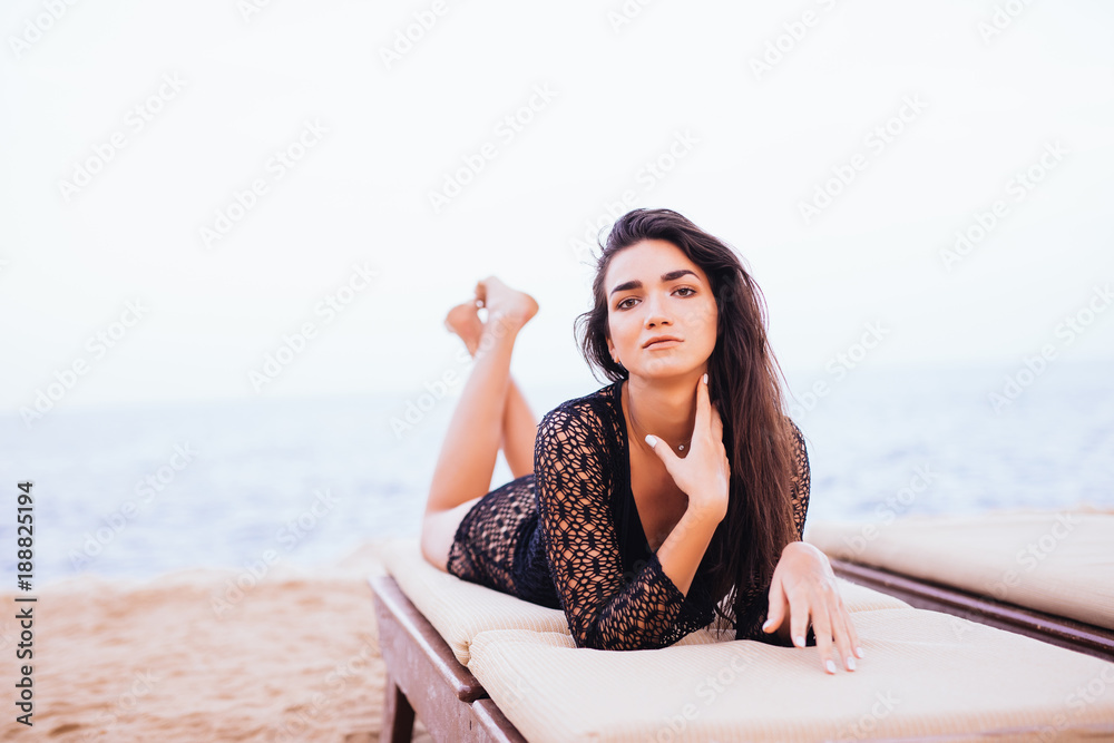 Beautiful woman lying on a deckchair at the sea beach