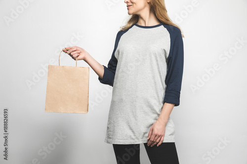 woman in stylish long sleeve on white with shopping bag