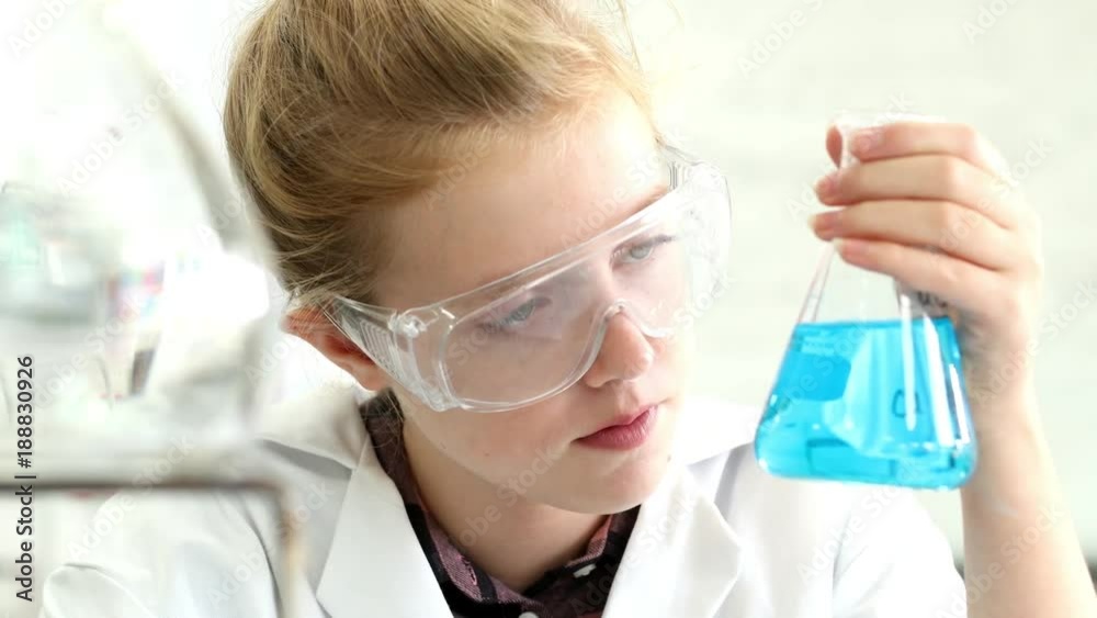 Female Pupil Conducting Chemistry Experiment In Science Class Female Pupil Conducting Chemistry Experiment In Science Class