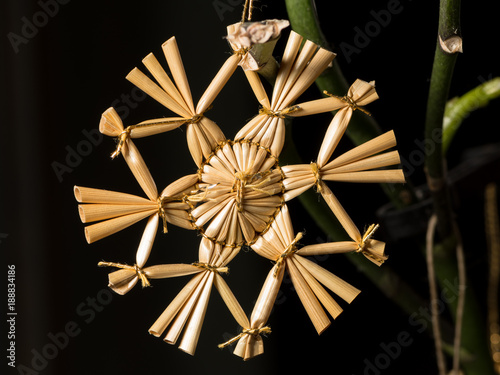 A straw star hanging on the christmas tree