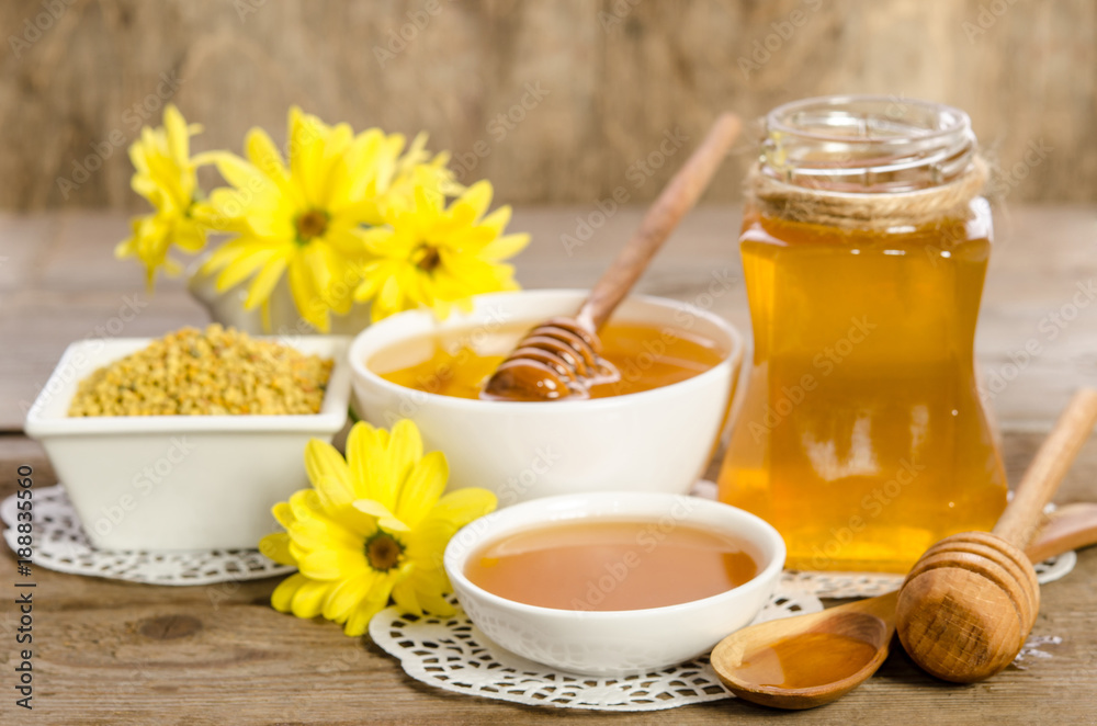Yellow flowers and bee products (honey, pollen) on wooden background Yellow flowers and bee products (honey, pollen) on wooden background