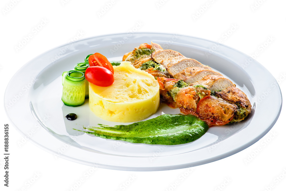 Grilled chicken fillet with pesto and sauce in a white plate isolated on white background
