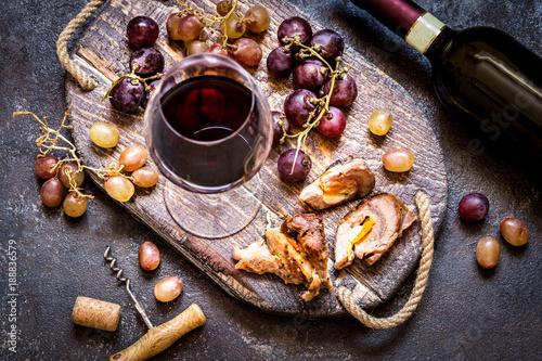 Red wine with grapes, meat, glass a glass on a wooden Board in a rustic style