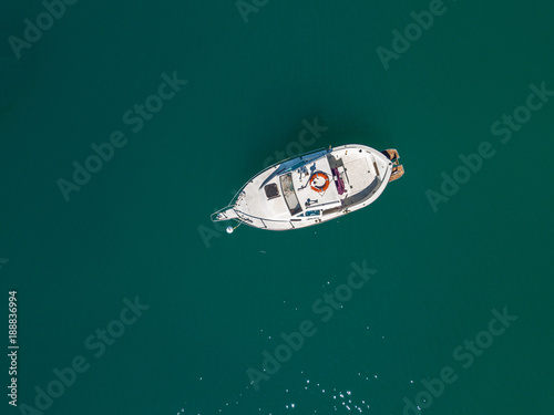 Vista aerea di una barca ormeggiata che galleggia su un mare verde. Immersioni relax e vacanze estive. Coste italiane, spiagge e rocce