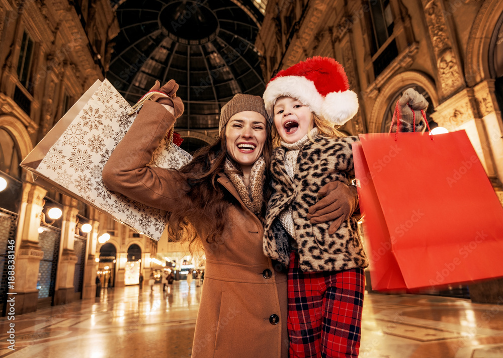 mother and daughter with Christmas shopping bags rejoicing