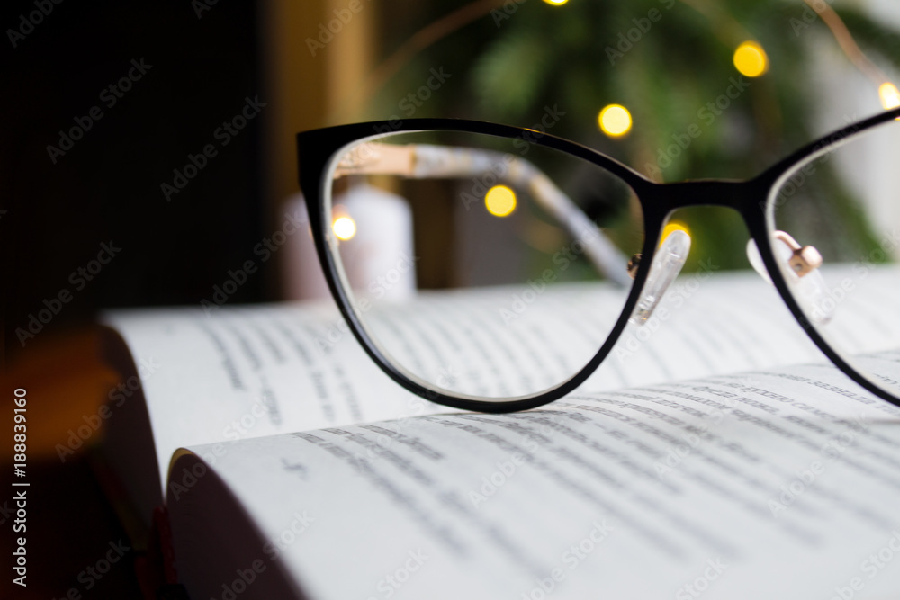 eyeglasses and open book on the desk eyeglasses and open book on the desk
