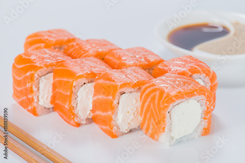Delicious Philadelphia sushi rolls with rice, cream cheese and salmon on light background