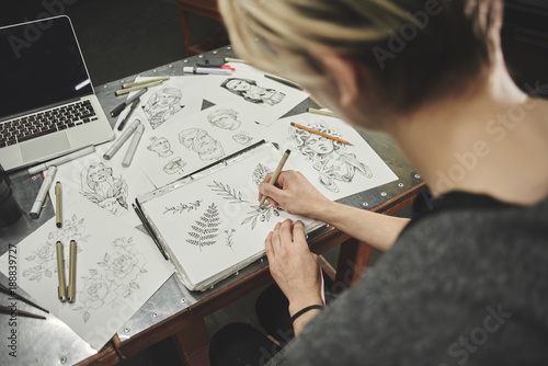 Portrait of a master calligrapher. A tattoo artist makes a sketch while sitting at a table in the Studio