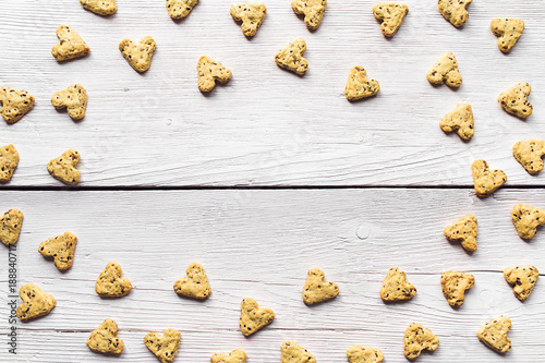 Homemade cookies with turmeric and flax seeds in the form of heart on white boards.