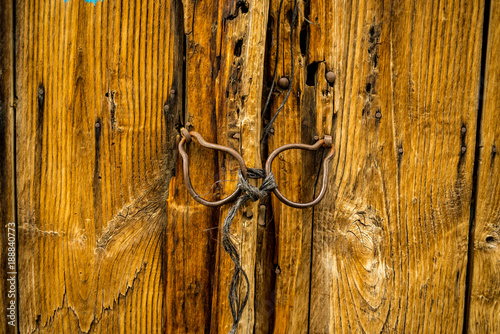 Fotografie Old  wooden door with ancient iron knockers