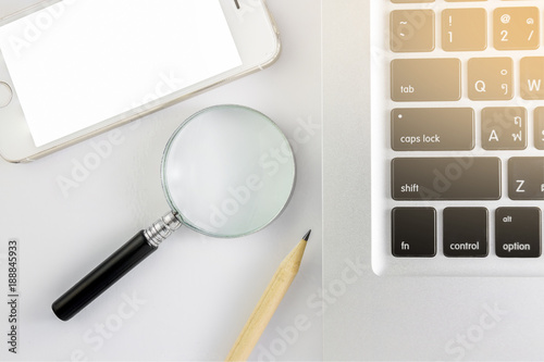 A magnifying glass and Pencil and notebook in white background by have light Shines in notebook