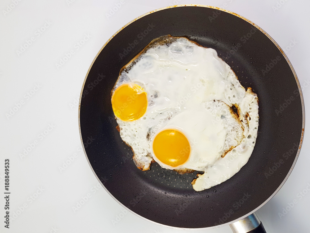 Fried eggs in pan with isolated white background, top view. Fried eggs in pan with isolated white background, top view.