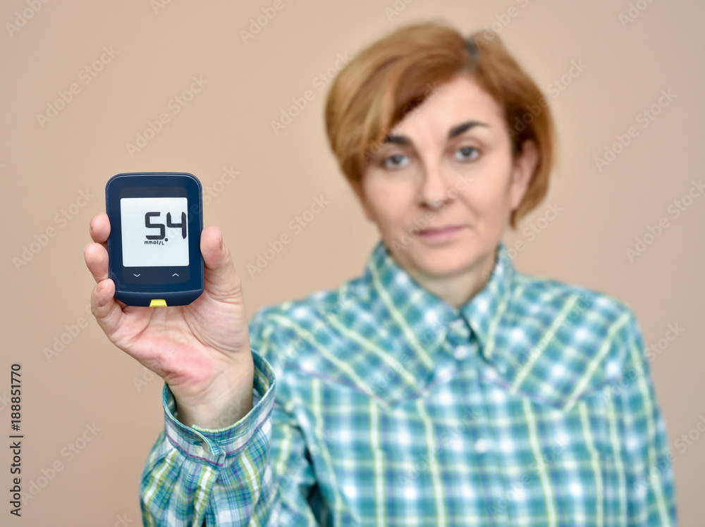 Woman showing glucose meter after measuring blood sugar. Selective focus. Woman showing glucose meter after measuring blood sugar. Selective focus.