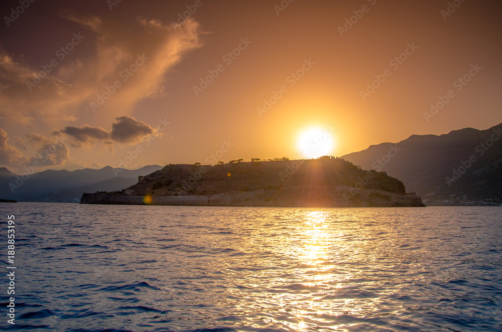 View of the island of Spinalonga with calm sea. Here were isolated lepers, humans with the Hansen's desease, gulf of Elounda, Crete, Greece. View of the island of Spinalonga with calm sea. Here were isolated lepers, humans with the Hansen's desease, gulf of Elounda, Crete, Greece.
