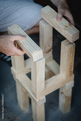 Hände bauen Turm aus Hölzern