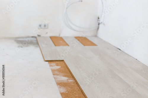 Installing light laminate floor with substrate under a laminate on white background